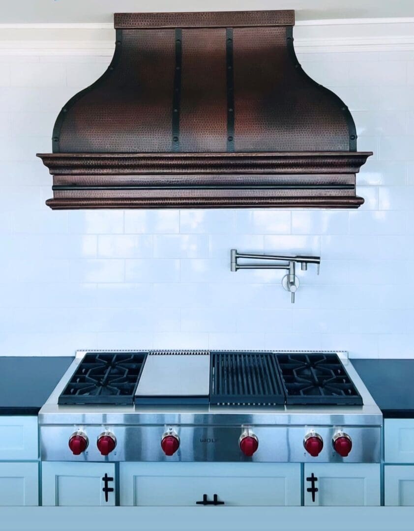 A kitchen with a stove and hood in it